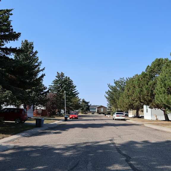 a street with cars parked on the side of a tree lined street at Kimberly Village, Cheyenne, Wyoming