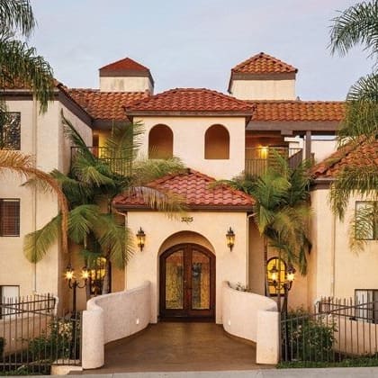 a large house with palm trees in front of it