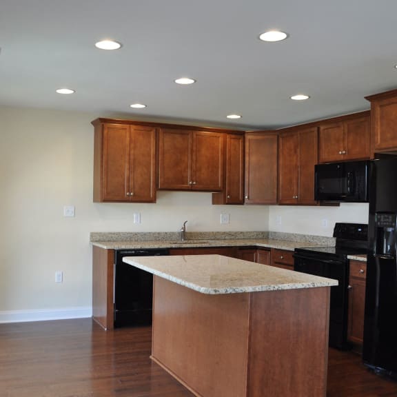 a kitchen with wooden cabinets and a granite counter top