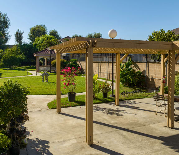 a patio with a pergola in a garden at Flamingo Garden Senior Apts, El Monte, CA 91732
