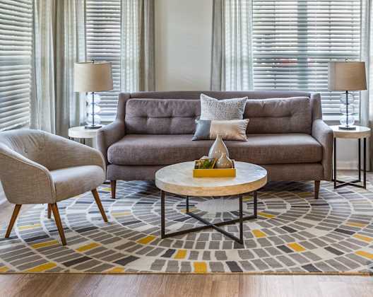 A living room with a grey couch, a coffee table, and a fireplace.