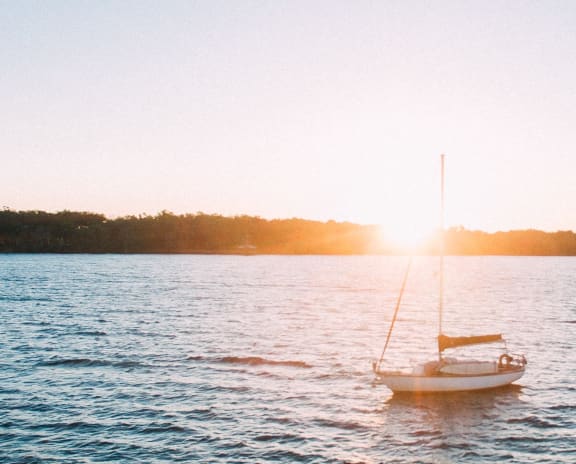 Large body of water with a sailboat on it.