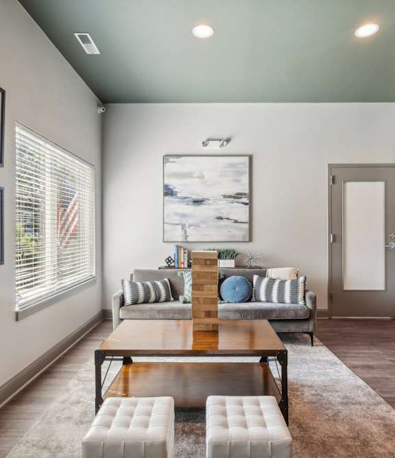A modern living room with a wooden coffee table and a painting on the wall.