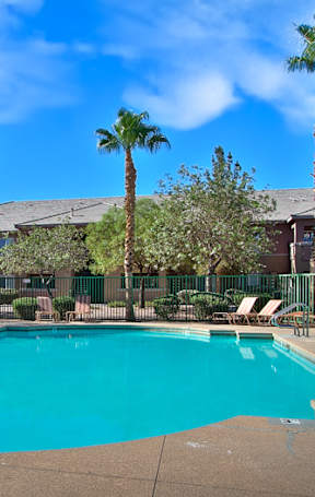 A large brown building with a pool in front.