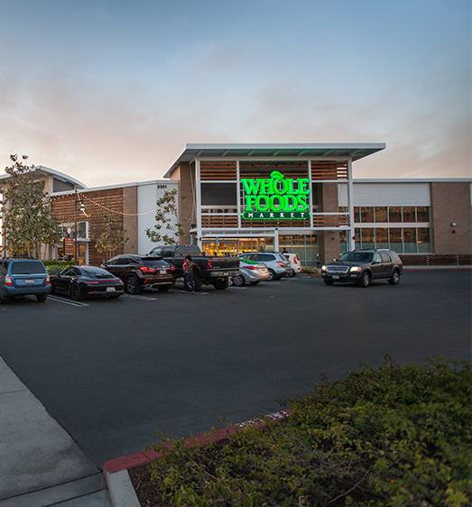 A parking lot with cars and a building with a sign that says Mendocino Farms.