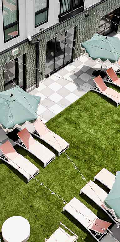 A patio with tables and chairs and umbrellas.