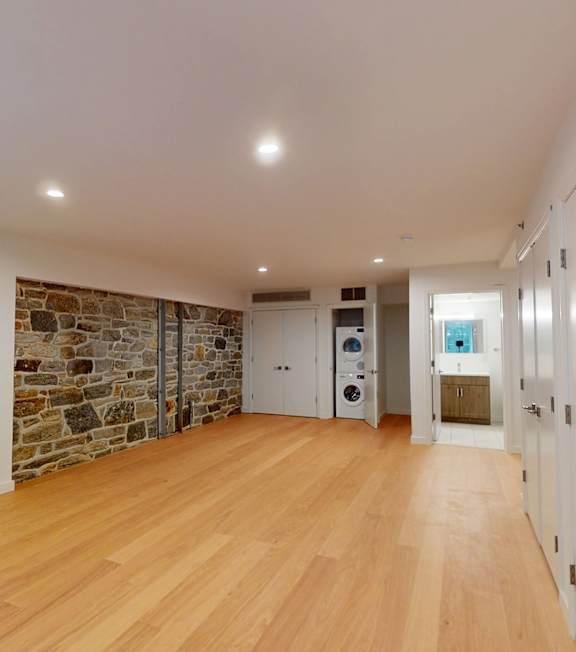 A large empty room with wooden floors and white walls.