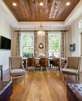Alexander Village Clubhouse interior view with wood flooring, couches, and arm chairs
