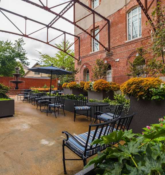 Apartment community courtyard with patio furniture and garden planters at The Tennessee Brewery Apartments, Memphis