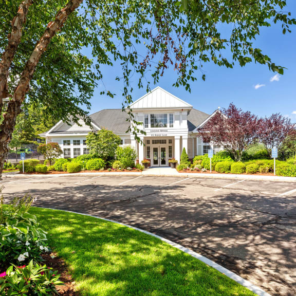 the front of a house with a driveway and trees