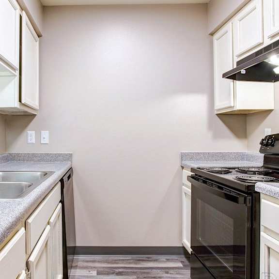 A kitchen with a black oven and a grey countertop.