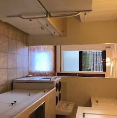 A bathroom with a large white tub and a window.