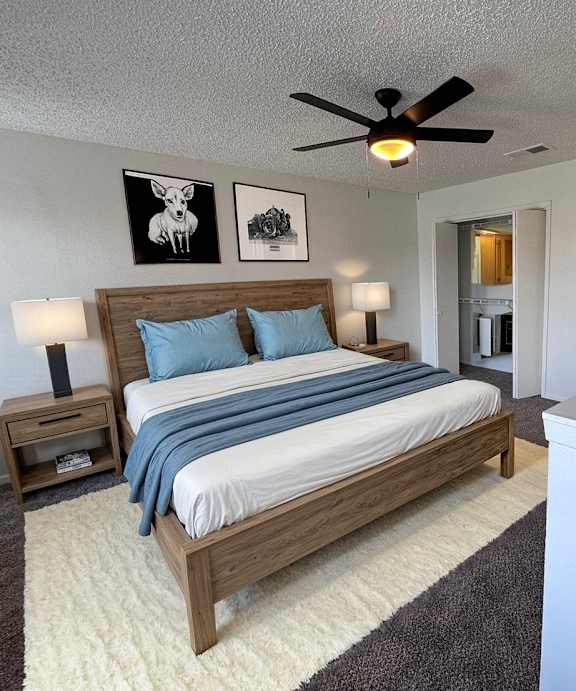 A bedroom with a bed, nightstand, and a ceiling fan.