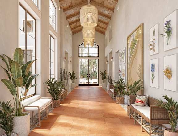 A long hallway with plants on either side and a bench in the middle.