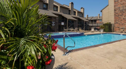 our resort style swimming pool is next to a brick building