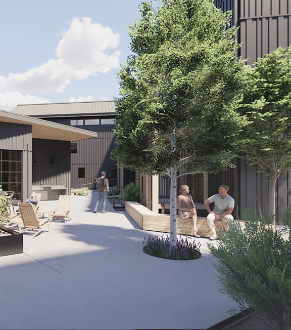 A modern building with a courtyard surrounded by trees and people sitting on benches.