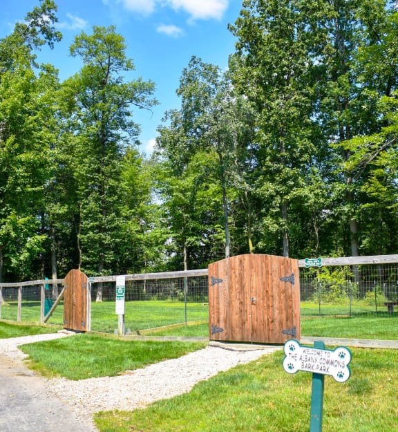 a gate in a fenced in area with trees in the background