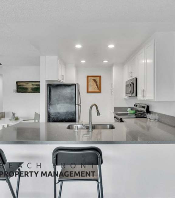 A well-lit, modern kitchen and living room with a dining area.