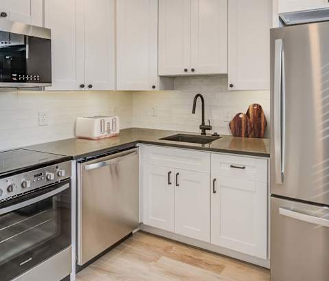 a kitchen with stainless steel appliances and white cabinets