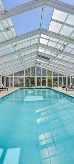 A large indoor swimming pool with a glass ceiling.