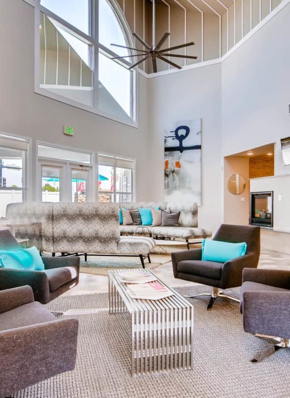 a living room with couches and chairs and a ceiling fan