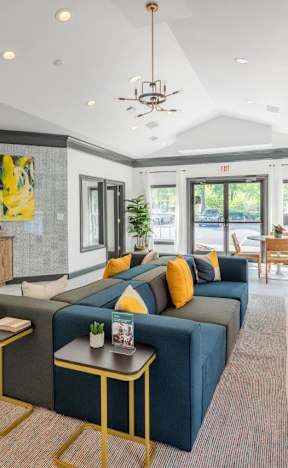 A living room with a blue couch and a chandelier.