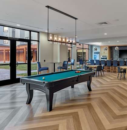 A room with a pool table and a shuffleboard table.
