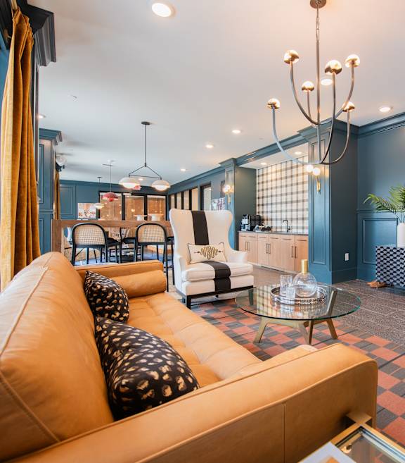 a living room with blue walls and leather furniture at The Fitzgerald in Spartanburg, SC 29302