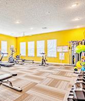 fitness center with cardio equipment and free weights at flats at sundown apartments in north port florida