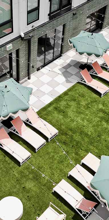 A patio with tables and chairs and umbrellas.