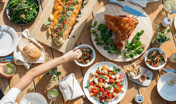 a group of people sitting around a table eating food