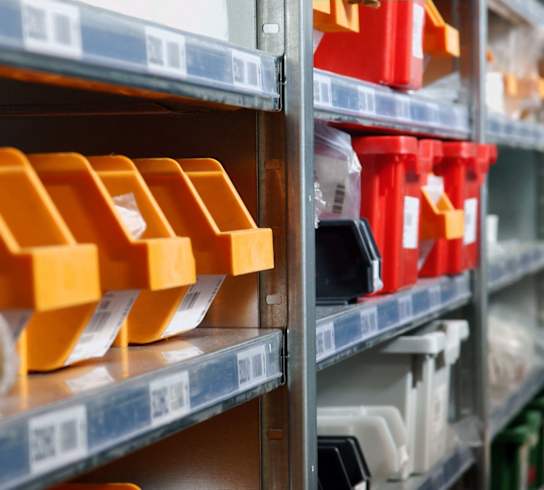 a shelf of plastic containers in a warehouse