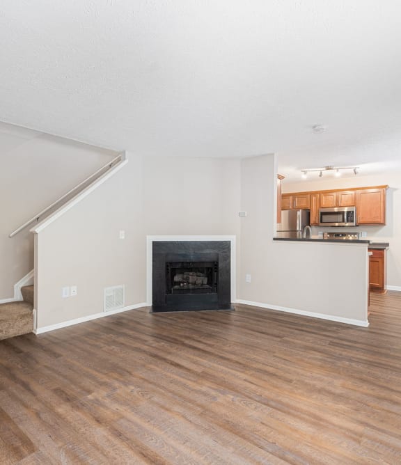 a living room with a fireplace and wooden floors