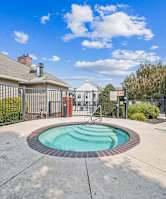 A small pool surrounded by a fence and a walkway.