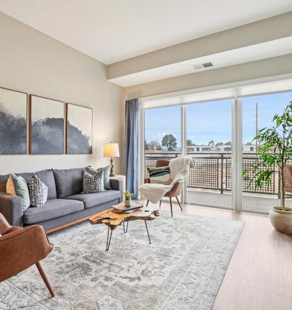 A living room with a grey couch, a brown chair, a coffee table, and a flat screen TV.