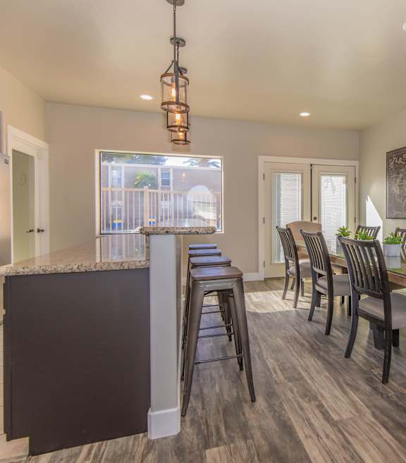 A kitchen with a bar and chairs.