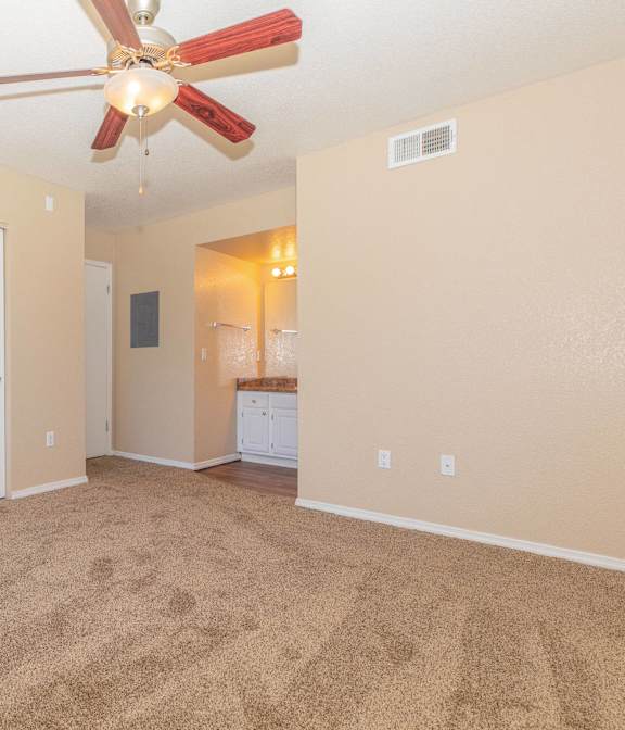 A room with a ceiling fan and carpeted floor from a 3 bedroom layout at Peak at Oro Valley Apartments