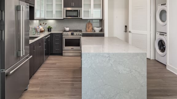 a kitchen with stainless steel appliances and white counter tops