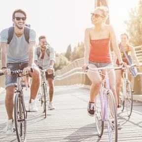 A group of people riding bicycles on a bridge.