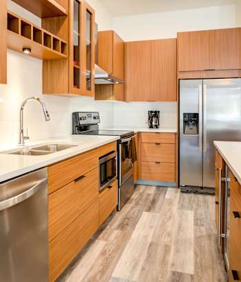 A kitchen with wooden cabinets and a stainless steel refrigerator at Central Park West.