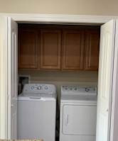 A white dryer and washer are in a small laundry room.