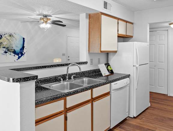 a kitchen with white appliances and wooden cabinets