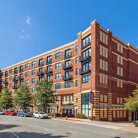 A large red brick building with a parking lot in front.