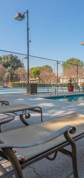 A pool with a bench and a table in front of it.