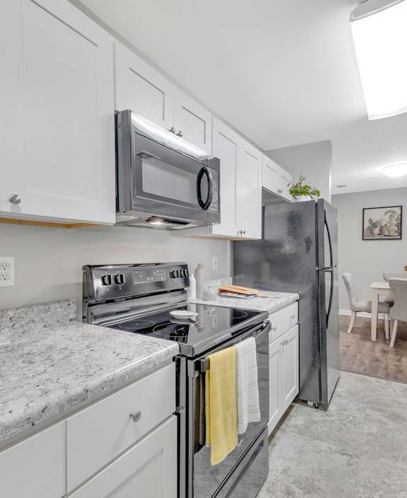 A kitchen with white cabinets and a granite countertop.