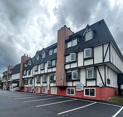 a large white and red building with a cloudy sky in the background at Kings Court, Anchorage