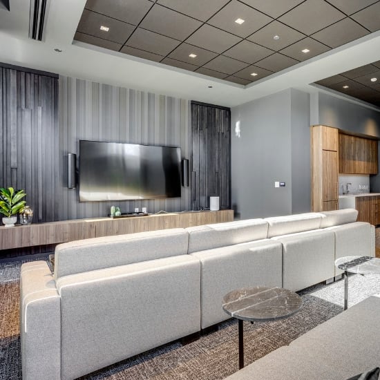 cinema room with two large white couches and a flat screen TV at Citizen on Jasper, Edmonton