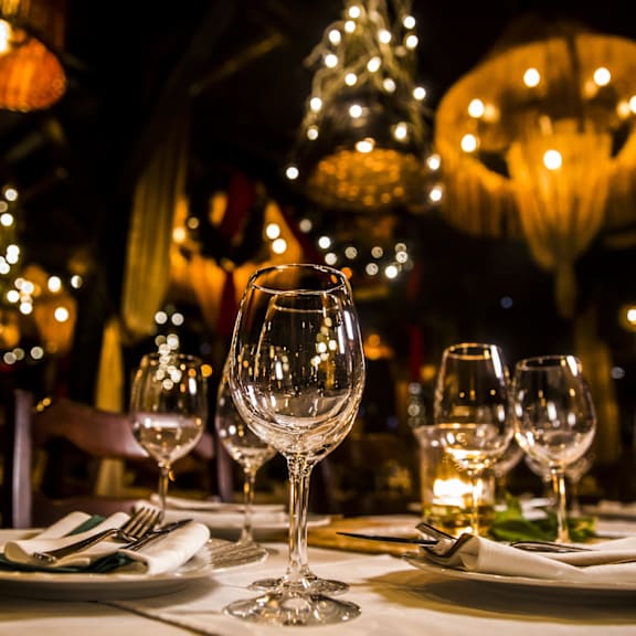 A table set for a meal with wine glasses and plates.