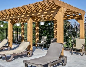 a pergola with chaise lounge chairs