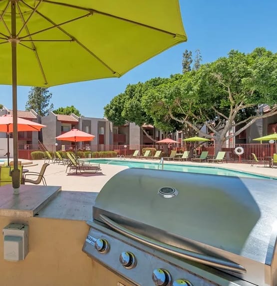 Poolside BBQ and Picninc Area with Lime Green Umbrella at Spring Meadow Apartments in Glendale, 85302